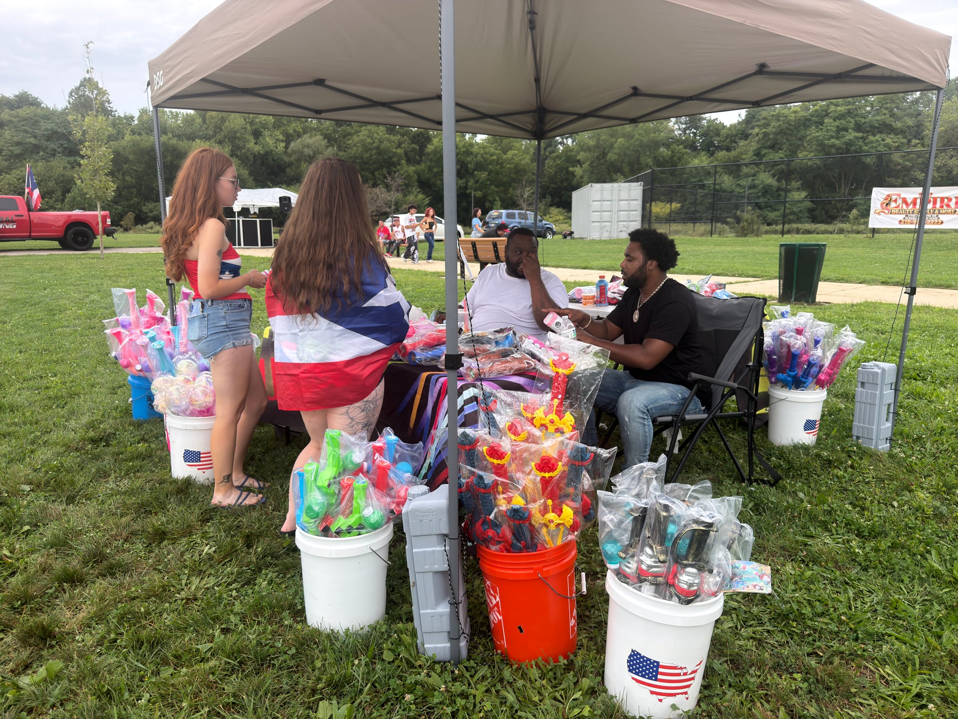 Visitors browsing a vendor stall with colorful toys and other merchandise.