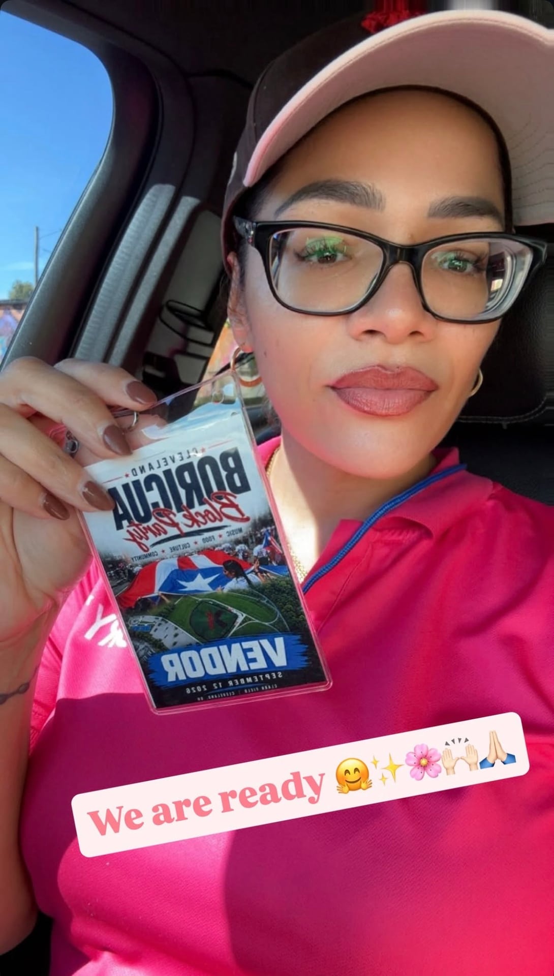 A shared selfie showing a person in glasses and a pink shirt holding a block party vendor badge.
