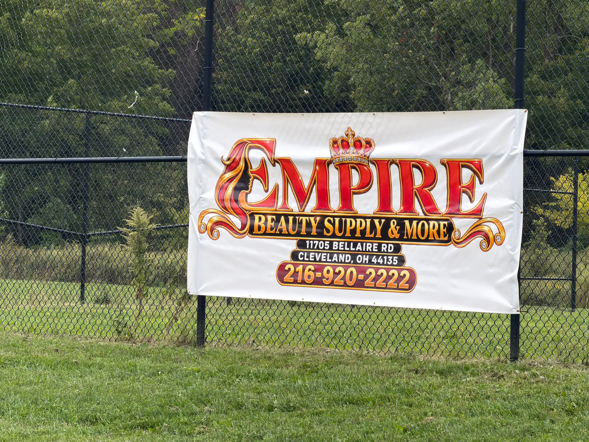 An Empire Beauty Supply and More banner attached to the field fence.